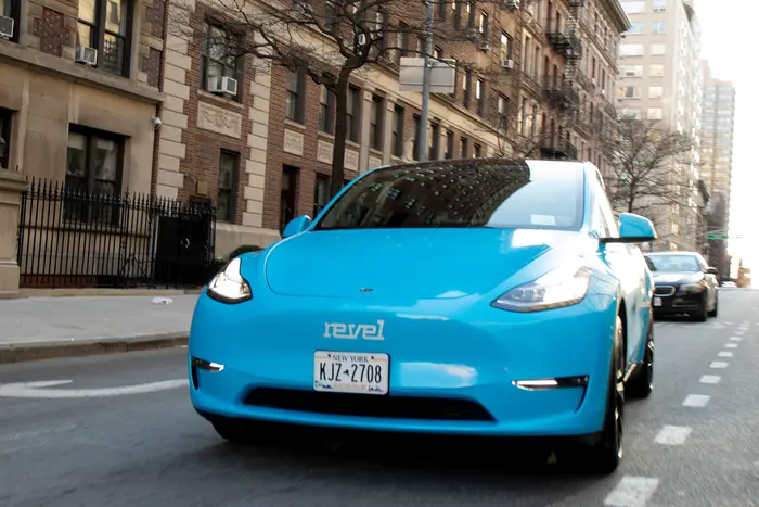 A blue Revel Tesla taxi on a NYC street